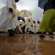 People walk through mud as they wait for the arrival of Pope Francis to celebrate a mass on the campus of the University of Nairobi.